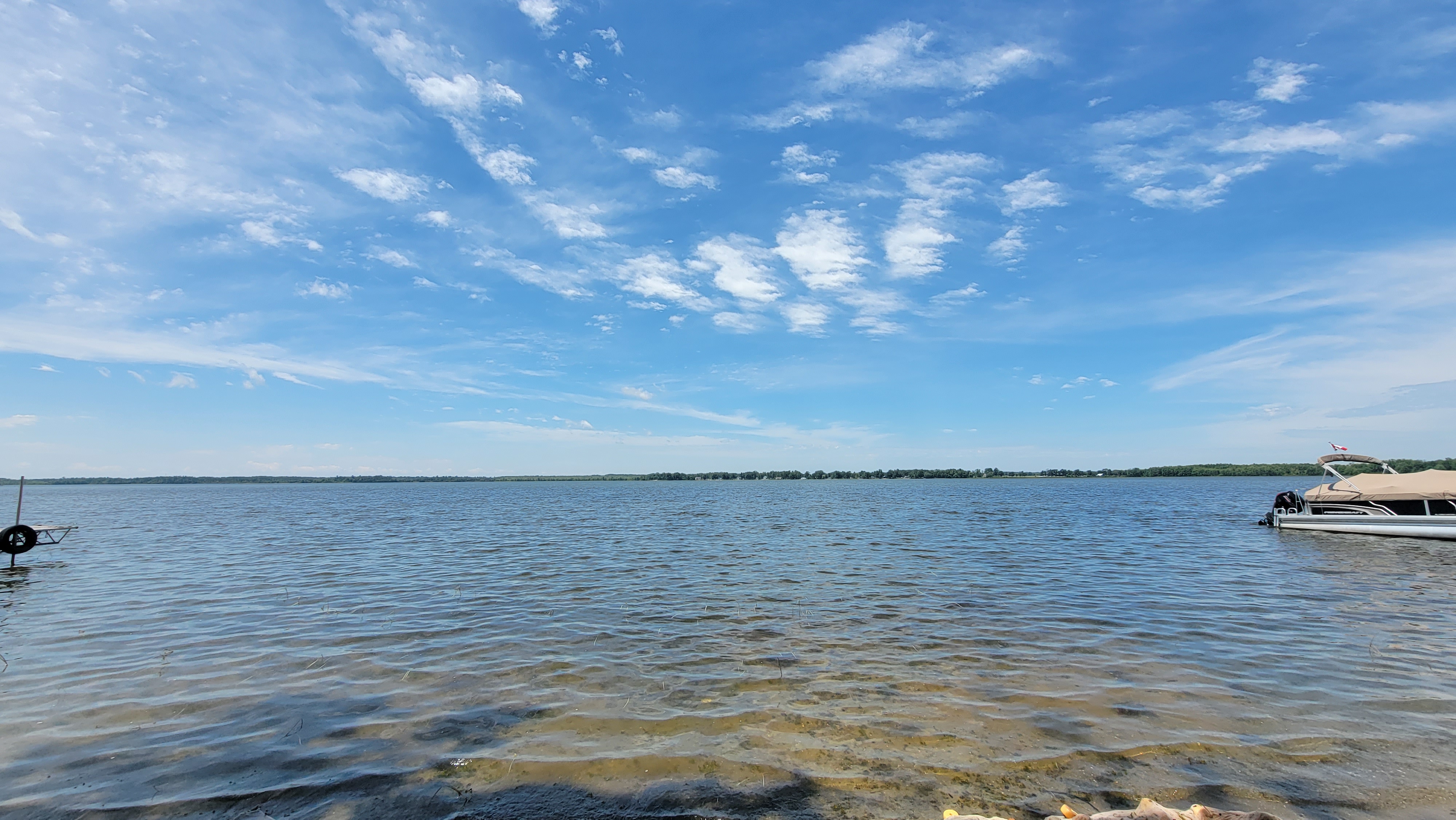 A shoreline picture of Lake Dalrymple, featuring clear waters and blue skies