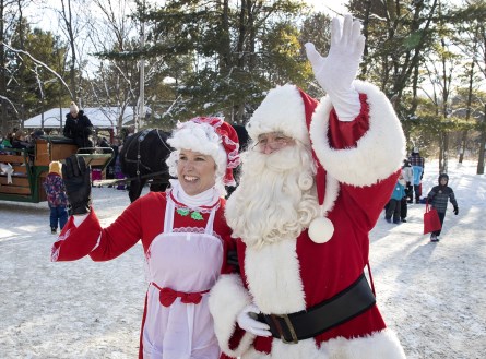 Mr. and Mrs. Claus waving at children